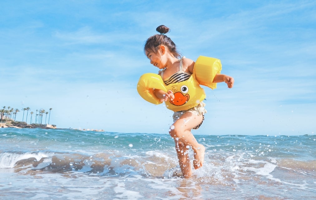 A little girl in summer beach, healthy after her paediatric consultation, Epping paediatrics clinic